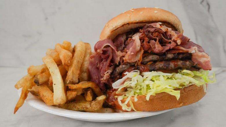 A pastrami burger with fries on a plate